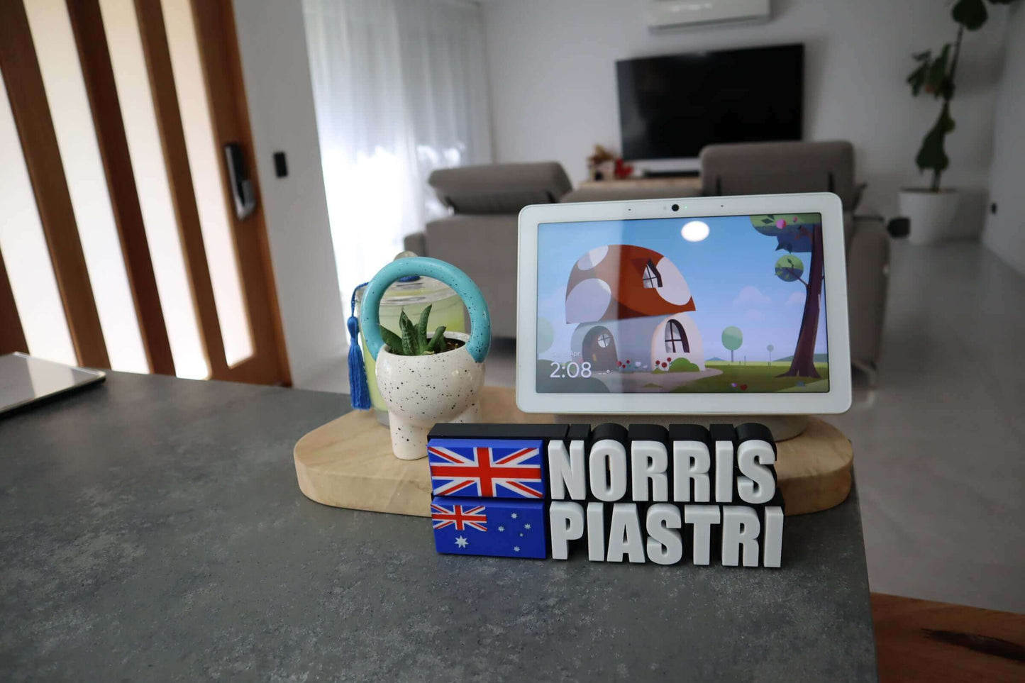 Customizable F1 Driver Name Plate featuring 'NORRIS PIASTRI' with Australian flag colors and a plant in the background.